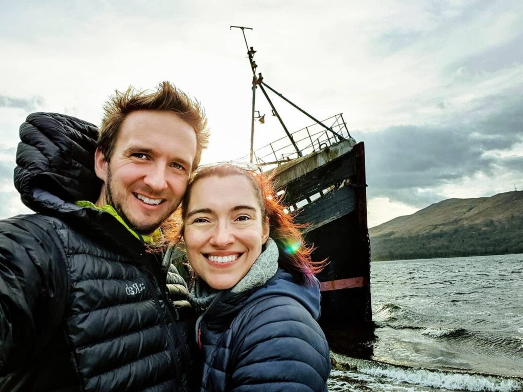 Marie and Alan take a selfie in front of a boat.