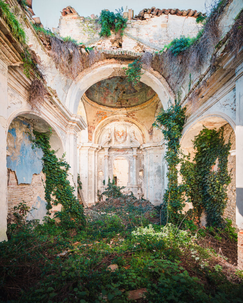 Greenery and moss, along with ivy grows across the crumbled building