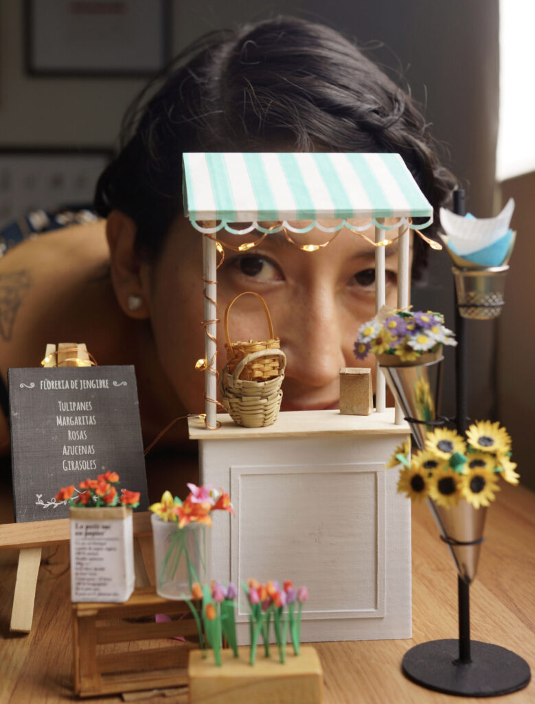 A woman looks in between a tiny flower stall.
