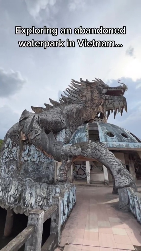 A dragon statue guards a tower in an abandoned waterpark