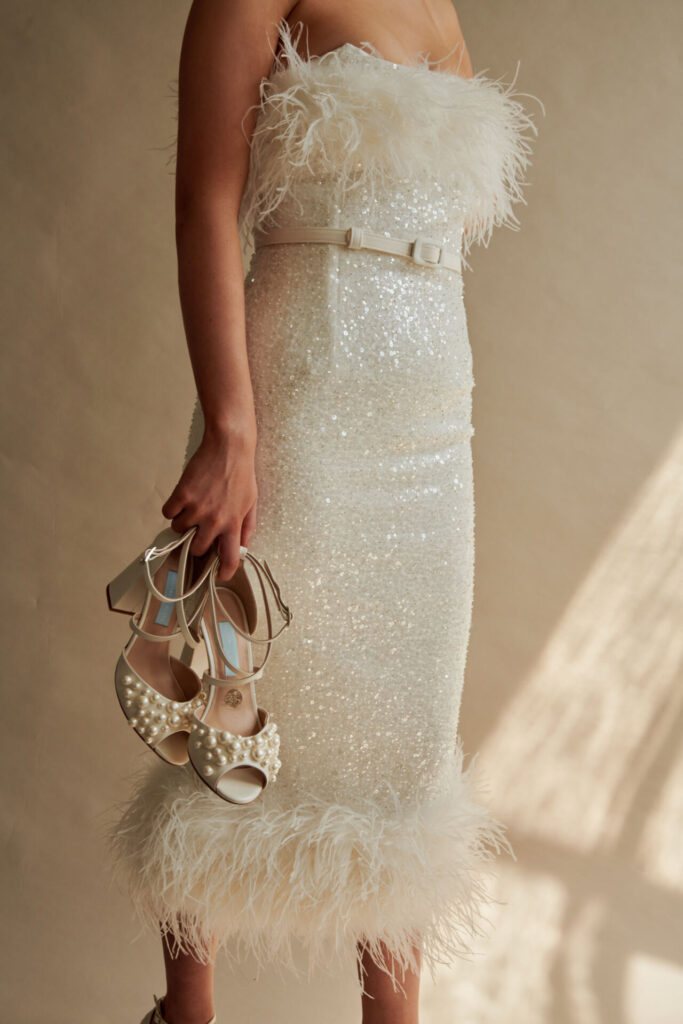 A bride holds a pair of Charlotte's shoes. 