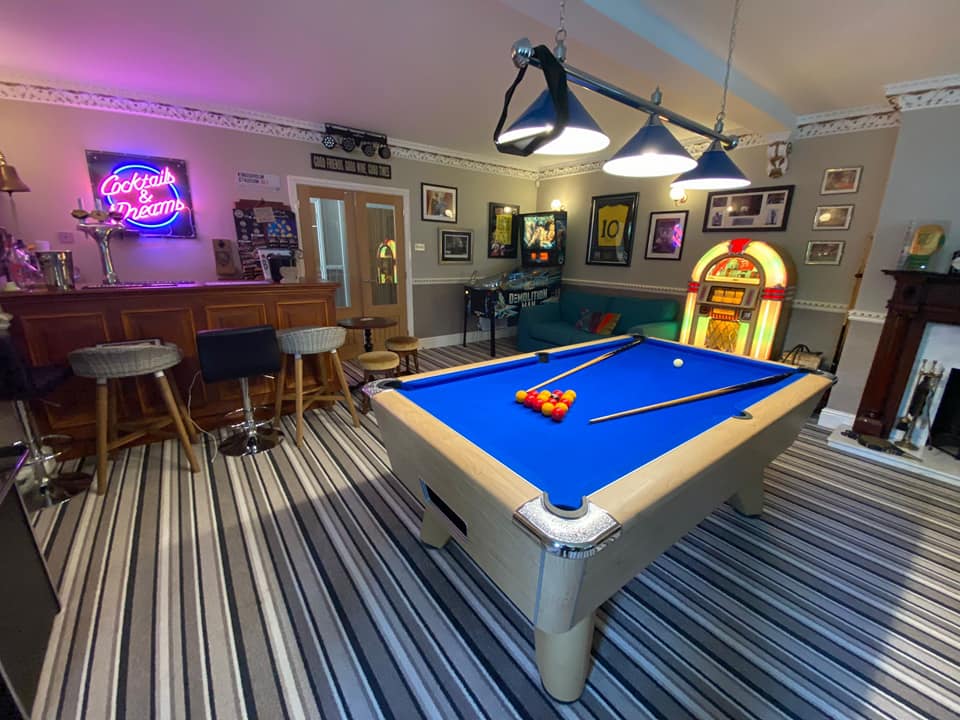 A blue pool table takes centre stage in Peter's games room. 